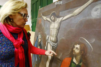La restauradora Marta Eva Castellanos muestra la pintura barroca de San Pedro de los Oteros ya recuperada por completo.
