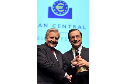 Trichet entrega una campana a su sucesor, Draghi.