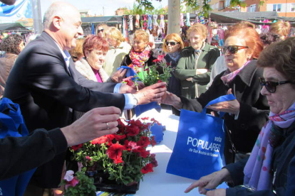 El candidato del PP repartió flores ayer en el mercadillo de Trobajo del Camino.