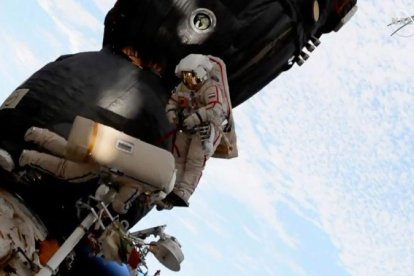Dos astronautas reparan el casco de la Soyuz durante un paseo espacial.