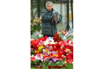 Un hombre observa las flores que recuerdan a las víctimas del teatro