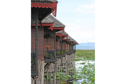 Casas sobre maderas en el lago Inle, a la derecha, una imagen cotidiana de la ciudad de Mrauk