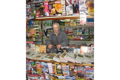 Antonio Blas posa en su quiosco, entre revistas, periódicos y chucherías.