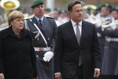 Merkel (izq) y el presidente de Panamá, Juan Carlos Varela, pasan revista a la guardia de honor antes de reunirse en la cancillería, en Berlín, este martes.
