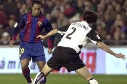 Ronaldinho trata de zafarse de la marca de Pellegrino en uno de los partidos de Valencia y Barcelona