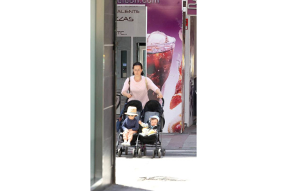 Una mujer pasea una pareja de bebés en León. RAMIRO