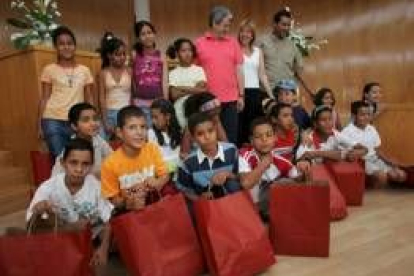 Los niños con sus regalos, posan  para la foto junto al alcalde, la concejala y el delegado saharaui