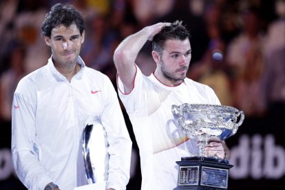 Nadal con gesto de triste con el trofeo de subcampeón al lado de un Wawrinka pensativo.