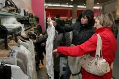 Una madre y su hija comprueban el descuento de una camisa en una céntrica tienda de Ponferrada