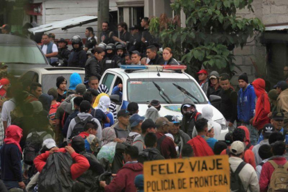 Migrantes hondureños hacen fila en un control policial donde se les verifica sus antecedentes penales y si tienen alguna orden de captura.