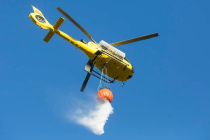 Un helicóptero suelta agua sobre un incendio en una imagen de archivo. DL