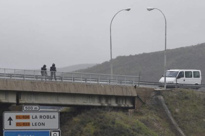 Dos antidisturbios se dirigen a una furgoneta policial sin distintivos en las inmediaciones del peaje de La Magdalena.