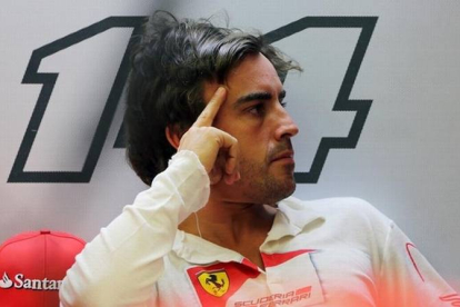 Fernando Alonso, con gesto de preocupación en el box de Ferrari.
