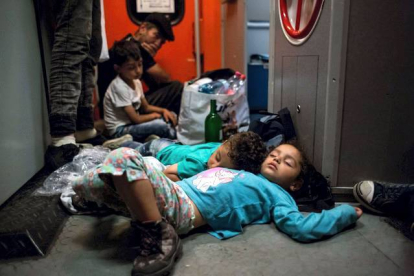 Unos niños duermen en la estación de trenes de Keleti mientras esperan poder viajar a Alemania desde Hungría.