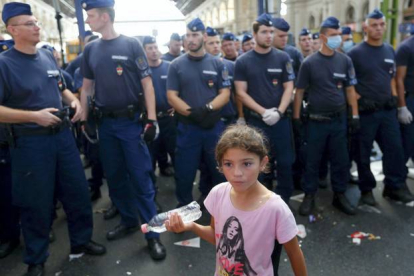 Una niña fotografiada frente a los policías que impiden la entrada de inmigrantes en la estación de trenes de Keleti, en Budapest, este martes.