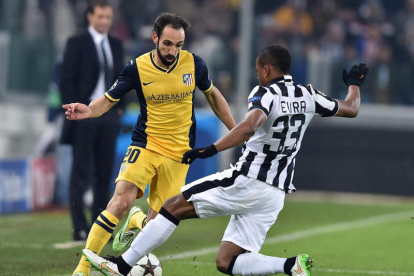 Patrice Evra pelea por el control del balón con el defensa del Atlético Juanfran Torres.