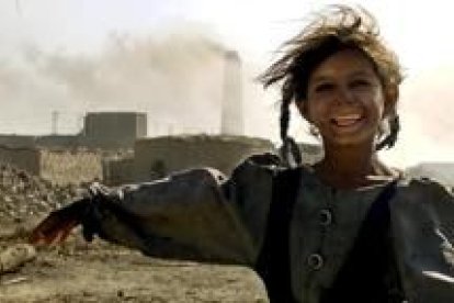 Una niña iraquí sonríe en frente de su casa que está dentro de una fábrica de ladrillos en Nahawan
