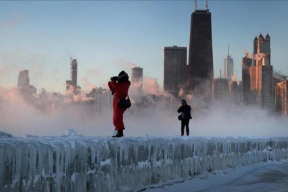Dos fotógrafos toman imágenes de la tormenta sobre la ciudad de Chicago.