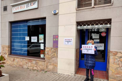 Una empleada posa este jueves a las puertas del café bar El Azar de Zamora, donde se ha vendido un décimo del número 44.469, agraciado con el segundo premio del sorteo extraordinario de El Niño.. EFE / MARIAM A. MONTESNOS