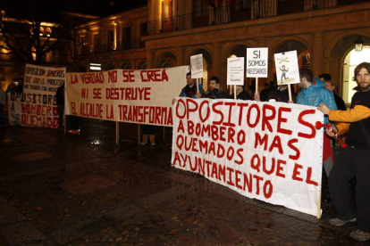 Opositores muestran sus pancartas de protesta ante el consistorio de San Marcelo.