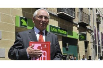El presidente de Caja Segovia, Atilano Soto, con el documento del SIP aprobado ayer, ante una sucurs