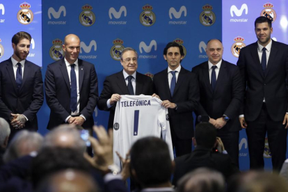 Florentino, durante la firma del acuerdo con Teléfonica, junto al presidente de la compañía, Álvarez-Pallete, y los técnicos y capitanes de las secciones de fútbol y baloncesto.