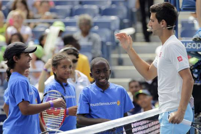 Novak Djokovic saluda a unos niños en la pista Arthur Ashe de Flushing Meadows.
