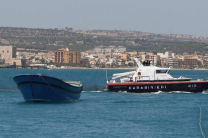 La barcaza con los cuerpos sin vida de 45 inmigrantes muertos por asfixia es trasladada al puerto de Pozzallo, este martes.