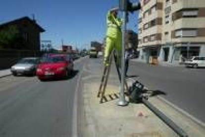 Uno de los operarios municipales procede a la instalación del nuevo semáforo