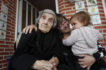 Bernardina Brasa, a la izquierda, junto a su nieta, Natalia Cazón, mientras ésta sostiene a su hija Luna. JESÚS F. SALVADORES