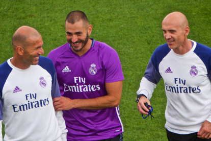 Zinedine Zidane bromea con el jugador Karim Benzema y con su asistente David Bettoni. ANDRE PICHETTE