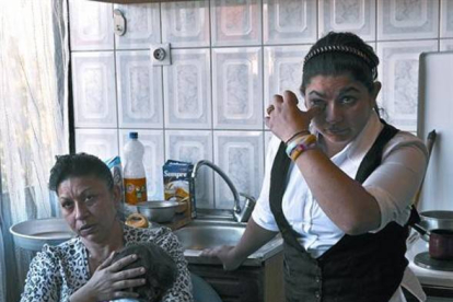 Leonarda Dibrani, de pie, se seca las lágrimas junto a su madre en su domicilio temporal en Mitrovica (Kosovo), ayer.