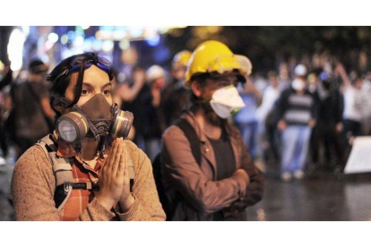 Una manifestante con máscara antigas ruega a los antidisturbios que no usen gas lacrimógeno, el sábado en la calle Istiklal de Estambul.