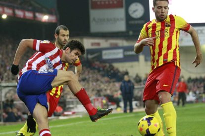 Diego Costa chuta a portería ante Jordi Alba y Mascherano, del FC Barcelona, durante el partido en el Calderón.