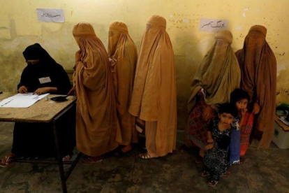 Mujeres ataviadas con burkas votan en un colegio electoral en Peshawar.