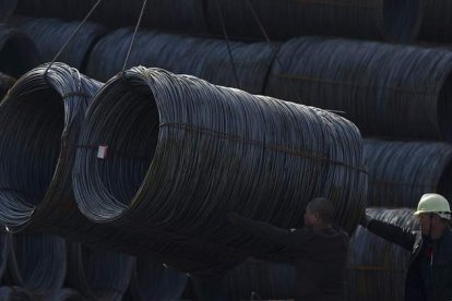 Dos obreros trabajan en una fábrica de acero en Shenyang, China. MARK