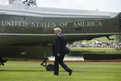 Trump camina por el jardín de la Casa Blanca antes de subir al helicóptero presidencial. M. REYNOLDS