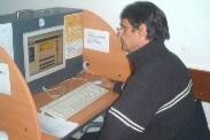 Un usuario del telecentro practica delante de uno de los diez puestos con ordenador