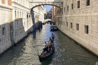 Una pareja disfruta de un viaje en góndola por un canal de Venecia. ANTONELLO NUSCA
