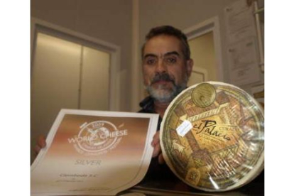 Cipriano de Lera muestra el queso premiado y el diploma que lo acredita.
