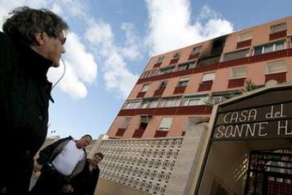 Una vecina observa el interior de una de las viviendas quemadas localizada en el casco urbano de Ben