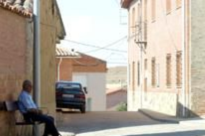 Un vecino de Castilfalé ve pasar las horas de la tarde en un banco del pueblo