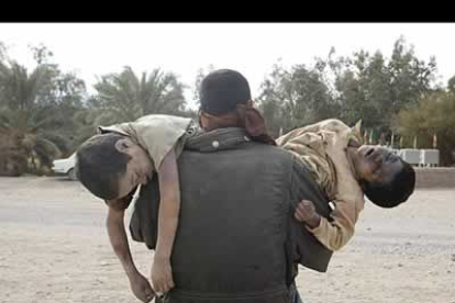 Un padre lleva a enterrar a dos de sus hijos, muertos en el terremoto de Bam (Irán)