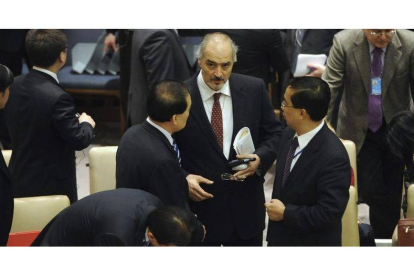 El embajador sirio en los EE.UU., Bashar Jaafari (c) habla con Li Baodong (i), representante permanente de China ante la ONU, antes de la reunión de Consejo de Seguridad que trata la situación en Siria, en la sede la ONU en Nueva York.