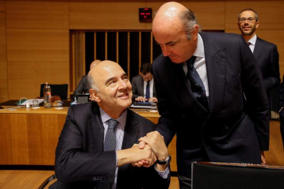 El comisario europeo de Asuntos Económicos y Financieros, Moscovici, saluda a De Guindos. J. WARNAND