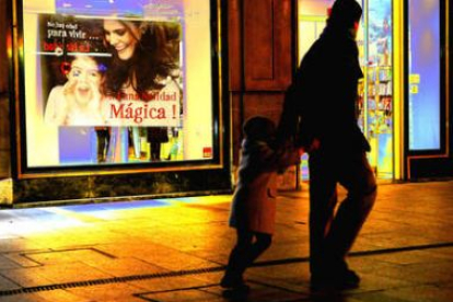 Un padre pasea en compañía de su hijo por una céntrica calle de León.