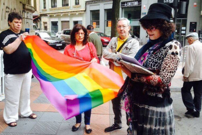 Representantes sindicales, políticos y colectivos gay despliegan la bandera multicolor antes de izarla en la sede de los sindicatos en León para conmemorar el Día del Orgullo Gay