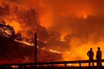 Operarios del equipo de bomberos observan el fuego que ha arrasado 25.000 hectáreas en el estado de California.