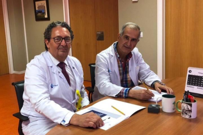 El gerente del Hospital Universitario de León, Juan Luis Burón, y el doctor Miguel Ángel Rodríguez García, firman la diligencia de toma de posesión como personal emérito