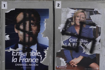 Pintadas en carteles electorales de Macron y Le Pen.